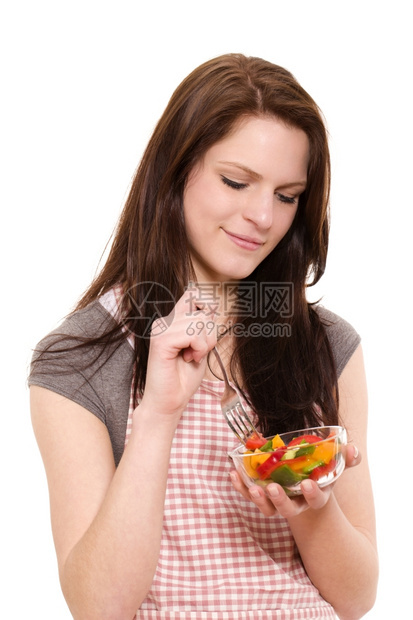 围裙胡椒钟带着笑脸的色拉微着美丽的女人在白色背景下吃混合沙拉图片