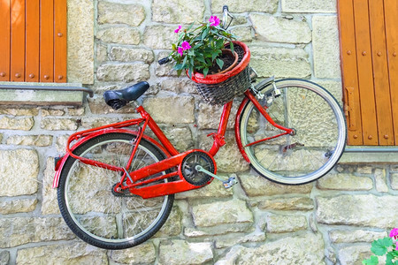 垂直的户外古董自行车在墙上篮子里放鲜花图片