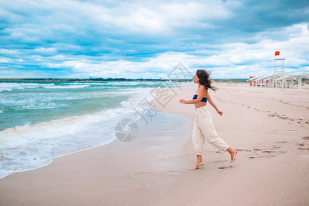 水宁静晴天热带海滩上白色沙的年轻美女图片