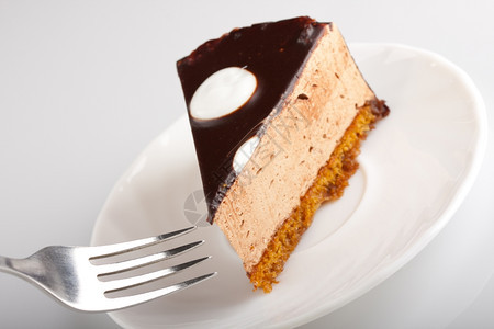 黑暗的白盘上美味巧克力蛋糕叉子浅色焦点奶油庆典图片