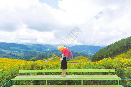 彩虹户外女孩亚洲拥有多色雨伞在花田中放松节假日旅行图片