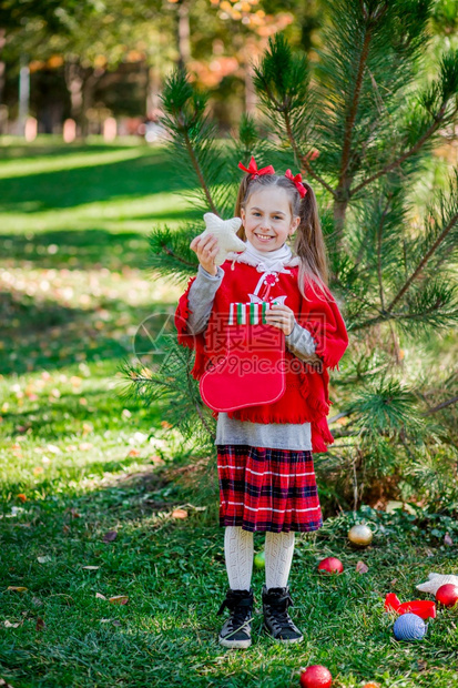 户外装饰圣诞树的小女孩图片