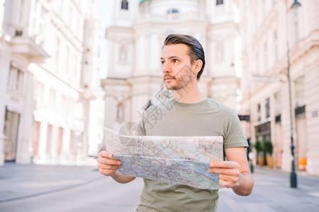 旅游欧洲老城市的街道上挂着城市的男游客在欧洲街上的白种男孩看欧洲城市时带着城市和背包的男游客一种图片