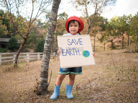 木头重用最后通牒持有拯救地球海报的小女孩展示了抗议森林中塑料污染的标志世界环境日零废物的概念而世界环境日零废物概念是和图片