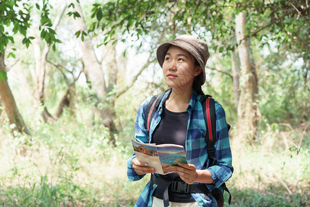 热带秋天亚裔女孩观光者以森林为质旅行青少年女在绿树的本质下正在轻松放绿色树木的本质下年轻图片