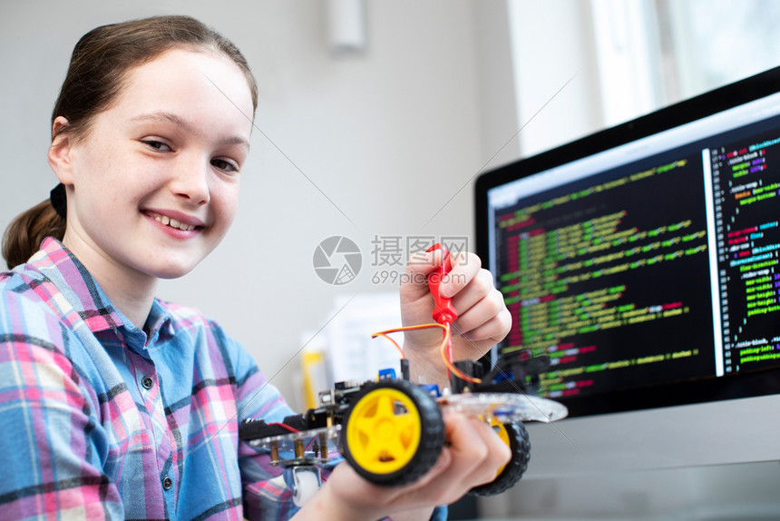 学校爱好女生在科课程中建造机器人汽车的肖像在职图片
