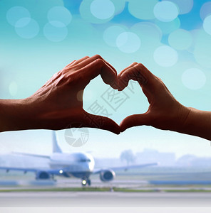 当甜心们在机场碰过时手的休眠片以心脏形式呈现出来轮廓旅行浪漫主义图片