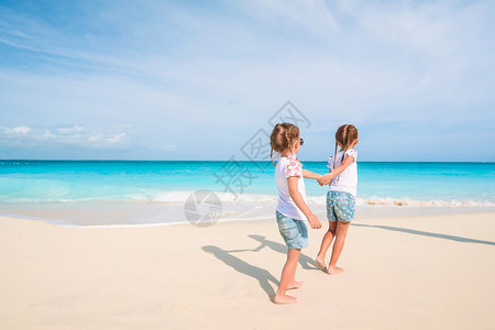 可爱的小女孩在海滩上可爱的小姑娘在海滩上玩得开心极了闲暇孩子图片