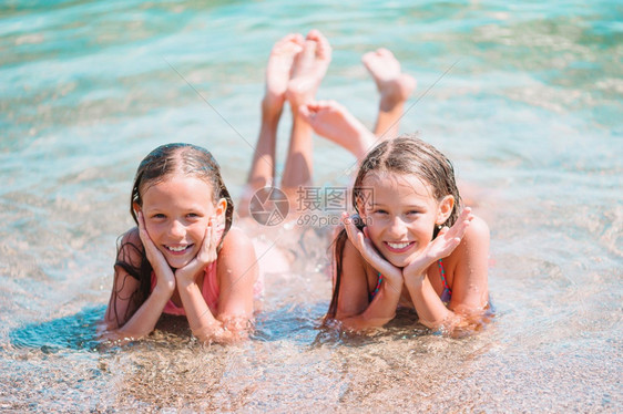 两个可爱的小女孩在沙滩上玩图片