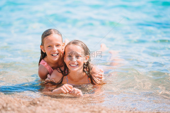 两个可爱的小女孩在沙滩上玩图片