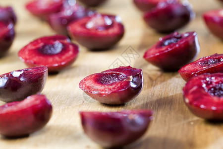 团体白木桌上的红甜樱桃切片准备用于烹饪的红甜樱桃切片多汁的健康图片