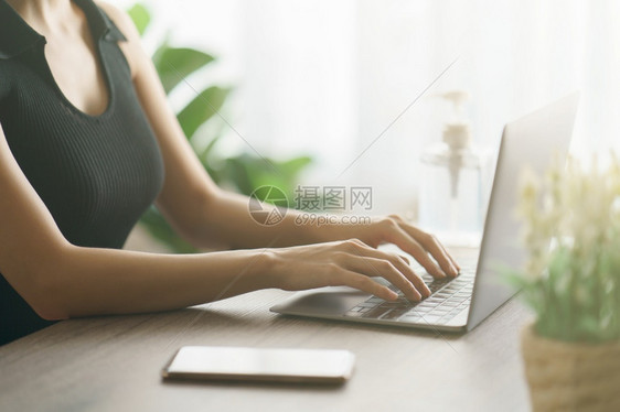 妇女使用笔记本电脑进行在线通信浏览和互联网瓶子屋办公室图片