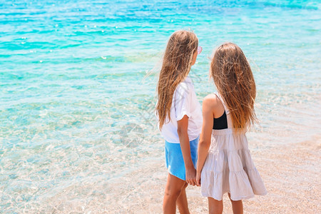 海滩上可爱的小女孩在海滩上玩得开心的可美小姑娘请享用白色的俏皮图片