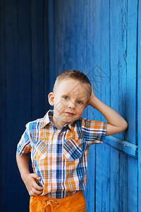 孩子们服装严肃的快乐美丽小男孩肖像站在古旧的条纹蓝色墙壁上图片