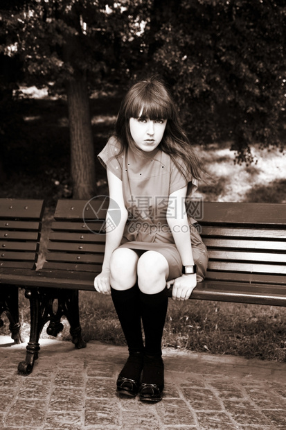 优雅坐在公园座椅上的年轻美女人类树图片