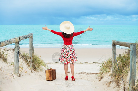 自由人们热的在海滩上穿旧式礼服的漂亮女旅行者图片