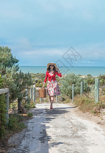 在海滩上穿旧式礼服的漂亮女旅行者海洋优质的图片