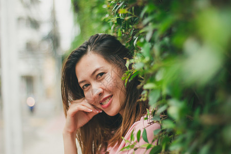 老的裙子白种人站在墙上遮着绿叶的妇女站立图片