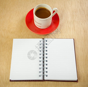 螺旋质地喝红杯热咖啡和关于木本的书图片