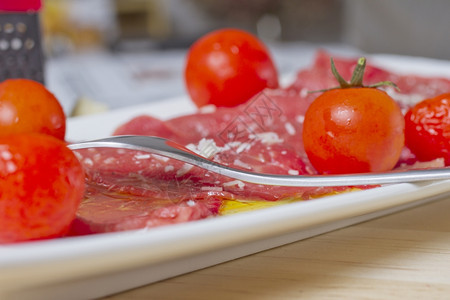 红辣椒和西柿在白色盘子上肉的削减图片