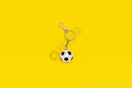 抽象的消极护符带有黄色背景的足球或钥匙链以最小的样式顶视图复制空间模板用于文本或您的设计图片