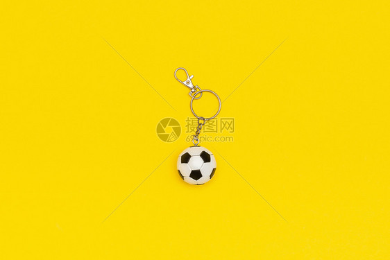 抽象的消极护符带有黄色背景的足球或钥匙链以最小的样式顶视图复制空间模板用于文本或您的设计图片