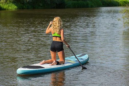 河上用桨板划船的女人图片