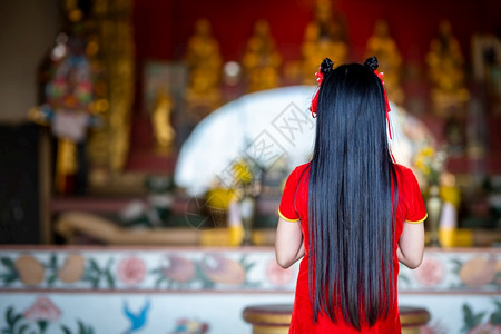 旗袍人们身着红色传统青山装饰的可爱亚洲年轻女子在泰国中华神庙为新年节举行布达雕像祷告仪式漂亮的图片