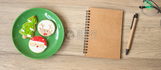 前夕红色的姜饼空白笔记本黑色圣诞饼干和木桌纸笔顶视图和复制空间Xmas新年快乐目标决议清单战略和计划概念图片