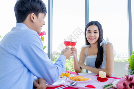 喝葡萄酒乐趣华伦多人节日概念快乐的亚洲年轻甜蜜情侣在餐厅背景上浪漫的午餐和熟连着烤红酒杯图片