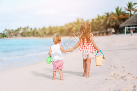 自然马尔代夫孩子们热带海滩上的小女孩一起玩耍快乐有趣的小女孩在热带海滩上玩得很开心图片