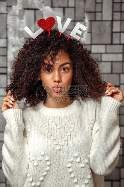 女象征一个年轻美丽的卷发女孩长着一双圆边头上刻着爱情的字词以嘴唇吻一个头发图片