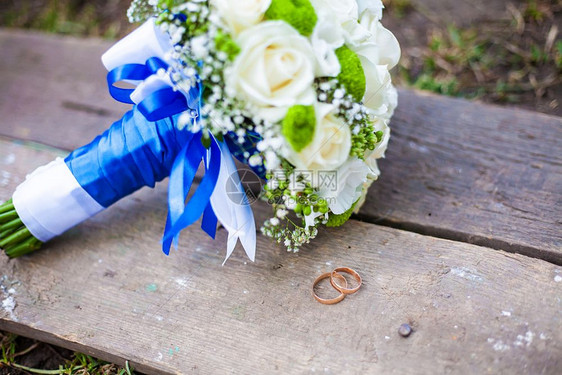 美丽的婚礼花束和戒指躺在木板凳上美丽的婚礼花束和戒指放在木板凳上新娘已婚装饰风格图片