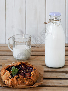 水平的可口带李子加莱特和带牛奶的瓶子特写早餐或午概念图片