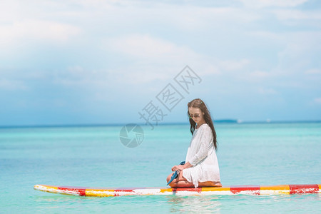 坐在桨板上冲浪的女人图片