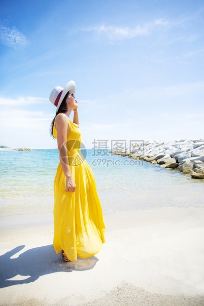 岛身着黄色衣服在夏日Vacaitton海滩轻松放的美丽亚洲年轻女明亮的漂图片