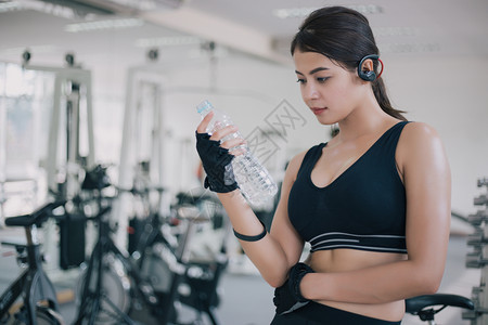 坐着运动型在健身锻炼后运动妇女作为的饮用水健康概念活力图片