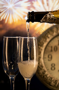 假期香槟杯午夜时钟和烟花新年灯喜庆的图片