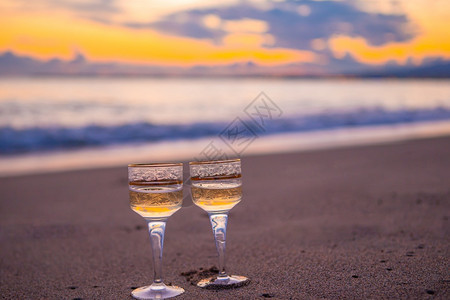 日落时在海滩上两杯怀特酒图片
