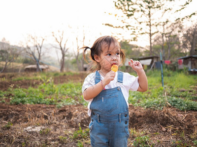 女微笑亚裔小孩在公园散步夏天脸色甜美地吃冰淇淋海滩图片