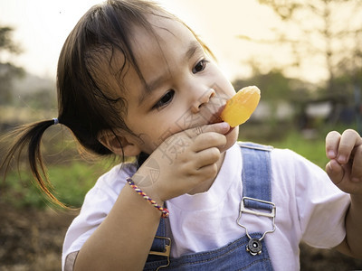 愉快乐的白色亚裔小女孩在公园散步夏天脸色甜美地吃冰淇淋图片