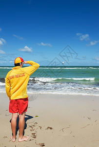 年轻男救生员查看海滩情况图片