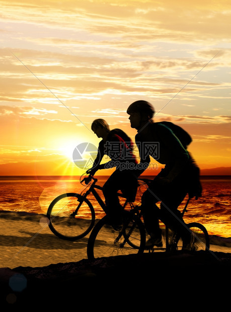一种骑自行车的夫妇在海边岩石缘运动西卢埃塔斯图片