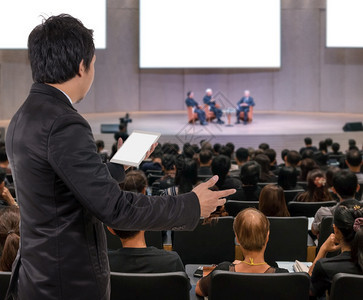 麦克风介绍商务人士会议发言的后视图在会议厅或研讨室的抽象模糊照片上具有与会者背景商业研讨会和教育理念专业的图片