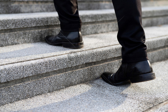 攀登现代商人在城市的楼梯上穿近腿干子赶着高峰时间在办公室工作匆忙上班在第一天上午工作楼梯软聚焦期间男柔软的图片