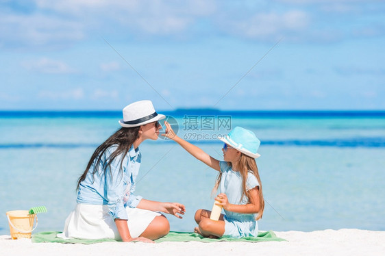 户外淑女保护不受紫外线辐射影响的概念年轻母亲对女儿在海滩上鼻子施阳光奶油年轻母亲对女儿施阳光奶油在海滩上流鼻血身体护理图片
