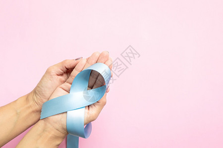 1月在前列腺癌症宣传月妇女身上带复制空间的浅蓝色丝带健康概念粉色的蓝国民图片
