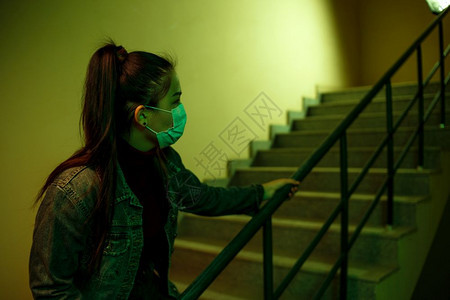 一名亚裔女孩在医院一个次疗面具楼梯的一次医用面罩上画像这个女孩回想起焦虑的恐惧女士肖像流感图片