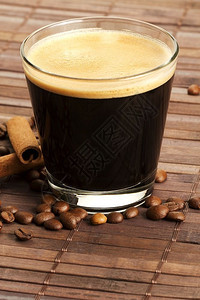 短杯咖啡含豆和来自二角顶层咖啡的肉桂短杯咖啡含豆和木底面的肉桂棒柔软戳棕色图片