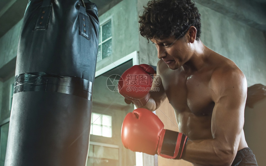 穿戴红色拳击手套和打袋的高加索肌肉男子在体育运动中锻炼时身穿红拳手套和击背心的肖像积极运动服斗争图片